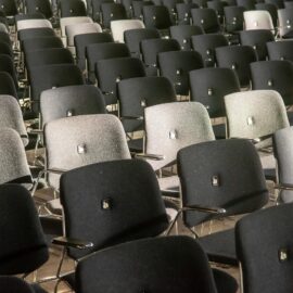Rows of black and gray chairs in an auditorium, showcasing comfort and style.