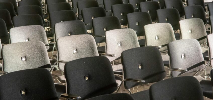 Rows of black and gray chairs in an auditorium, showcasing comfort and style.
